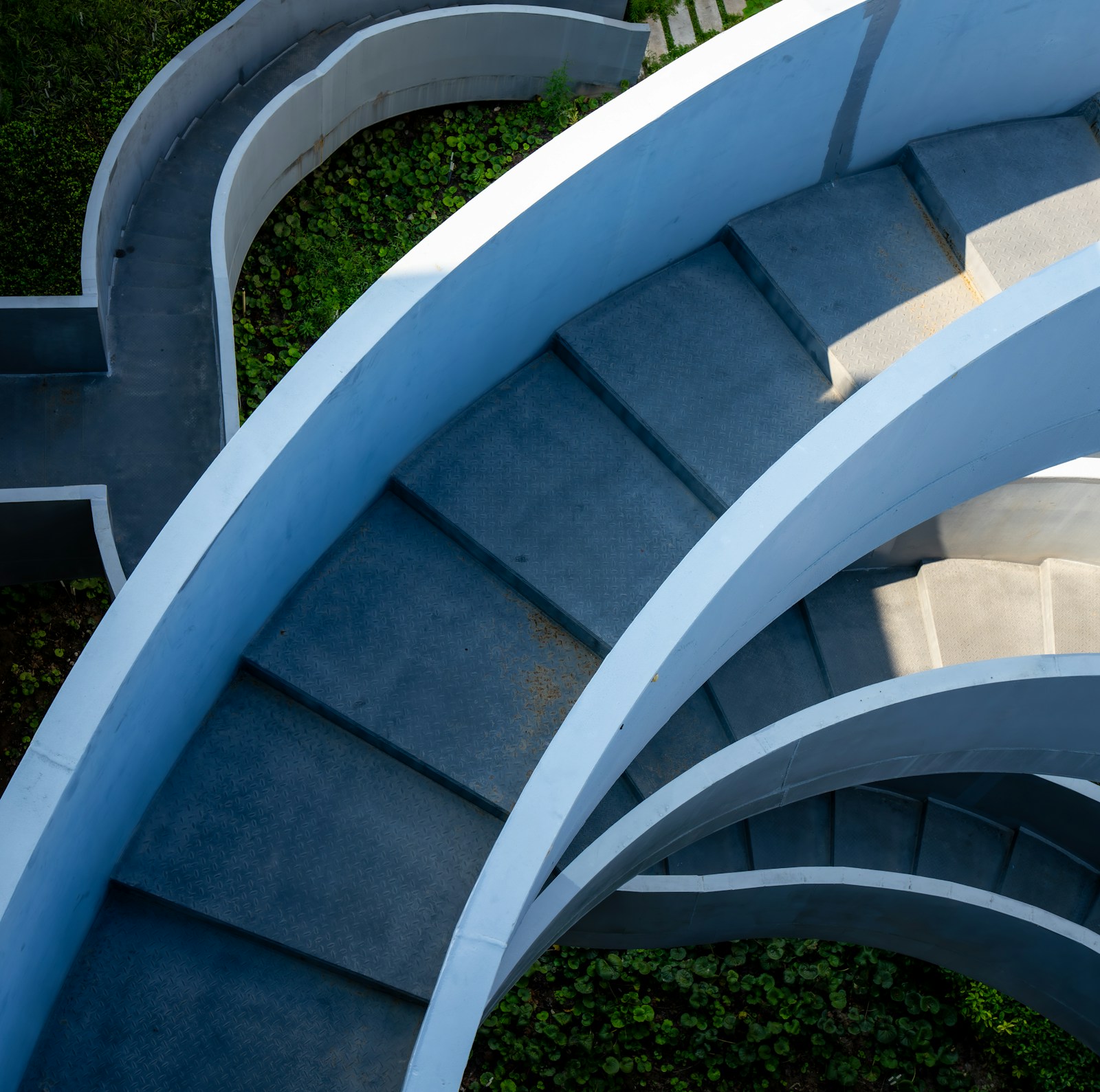 A sculptural stairway curving through greenery